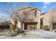 Two-story home featuring a two-car garage, desert landscaping, and a welcoming facade at 7516 Evening Melody Ct, Las Vegas, NV 89178