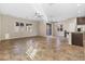 Open-concept living room featuring tile flooring, lots of windows, and adjacent kitchen with island at 7516 Evening Melody Ct, Las Vegas, NV 89178