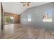 Bright living room features wood-look floors, vaulted ceilings, a wood accent wall, and a sliding glass door to the backyard at 8389 Charlton Valley Ct, Las Vegas, NV 89123