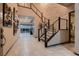 Stunning foyer featuring a modern staircase, elegant tile flooring, and stylish art decorations on the wall at 8560 Foundry Branch Ln, Las Vegas, NV 89113