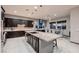 Spacious kitchen with stainless steel appliances, dark wood cabinets, and a large island with countertop seating at 8560 Foundry Branch Ln, Las Vegas, NV 89113