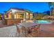 Outdoor dining area with a built-in bar and grill overlooking a beautiful pool and spa at 8808 Rozetta Ct, Las Vegas, NV 89134