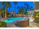 Inviting backyard featuring a sparkling pool, daybed, mature palm trees, and spa for relaxation and entertainment at 8808 Rozetta Ct, Las Vegas, NV 89134