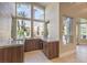 Stylish bar area with modern cabinetry, granite countertops, a wine fridge, and a view of the outdoor space at 8808 Rozetta Ct, Las Vegas, NV 89134