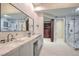 Modern bathroom featuring double sinks with marble countertop, glass shower, and walk-in closet access at 8808 Rozetta Ct, Las Vegas, NV 89134