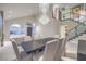 Bright dining area with a contemporary chandelier, large table, and staircase at 8808 Rozetta Ct, Las Vegas, NV 89134