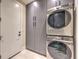 Laundry room boasts gray cabinets and a stacked washer and dryer at 8808 Rozetta Ct, Las Vegas, NV 89134