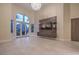 Expansive living room with floor-to-ceiling windows, chandelier, custom entertainment center, and outdoor access at 8808 Rozetta Ct, Las Vegas, NV 89134