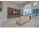 Comfortable living area with built-in shelving, a ceiling fan, and large windows offering views of the lush surroundings at 8808 Rozetta Ct, Las Vegas, NV 89134