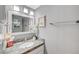 Small bathroom with a gray granite countertop and decorative mirror at 8908 Rocky Shore Dr, Las Vegas, NV 89117