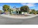 Two-story green home with large tree, front yard xeriscape landscaping and an attached three-car garage at 8908 Rocky Shore Dr, Las Vegas, NV 89117