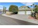 Two-story green home with three-car garage and manicured xeriscape front yard at 8908 Rocky Shore Dr, Las Vegas, NV 89117