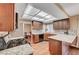 Bright kitchen features wood floors, wood cabinets, granite countertops, and a view into the dining room at 8908 Rocky Shore Dr, Las Vegas, NV 89117