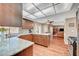 An open kitchen with a large counter, wood cabinets and hardwood floors extending into the living room at 8908 Rocky Shore Dr, Las Vegas, NV 89117