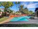 Stunning backyard pool with custom decking, mature palms, and lush landscaping, perfect for relaxation and recreation at 8908 Rocky Shore Dr, Las Vegas, NV 89117