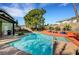 Beautiful backyard with large pool, lush landscaping, and covered patio at 8908 Rocky Shore Dr, Las Vegas, NV 89117