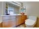 Bathroom featuring wood cabinets, a large mirror, and a toilet with an electronic bidet at 928 Allure Dr, Las Vegas, NV 89128