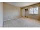 Neutral carpeted bedroom with sliding closet doors and a view of the backyard at 928 Allure Dr, Las Vegas, NV 89128