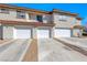 Townhouse featuring three attached garages with long driveways and desert landscaping at 928 Allure Dr, Las Vegas, NV 89128