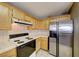 A kitchen featuring stainless steel appliances, wood cabinets, tile floors, and tile countertops at 928 Allure Dr, Las Vegas, NV 89128