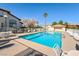 Community pool surrounded by lounge chairs and lush landscaping under a clear sky at 928 Allure Dr, Las Vegas, NV 89128