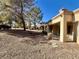 Backyard with desert landscaping, covered patio, and mature trees at 9437 January Dr, Las Vegas, NV 89134