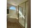 Bathroom featuring a glass-enclosed shower, soaking tub, and arched window at 9543 Antelope Bend Ct, Las Vegas, NV 89148