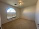 Neutral carpeted bedroom featuring an arched window and modern lighting at 9543 Antelope Bend Ct, Las Vegas, NV 89148