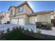 A beige two-story home with a two-car garage and manicured front yard at 9543 Antelope Bend Ct, Las Vegas, NV 89148