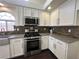 A bright kitchen featuring white cabinets, light countertops, stainless steel appliances, and dark hardwood flooring at 9543 Antelope Bend Ct, Las Vegas, NV 89148