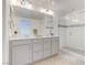 Bright bathroom featuring a double vanity with gray cabinetry and a glass-enclosed shower at 10089 Bismuth St, Las Vegas, NV 89183