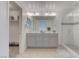 Bright bathroom featuring a double vanity with gray cabinetry and a glass-enclosed shower at 10089 Bismuth St, Las Vegas, NV 89183