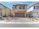 Two-story home featuring a paver driveway leading to an attached two-car garage and neutral desert landscaping at 10089 Bismuth St, Las Vegas, NV 89183