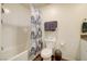 Bathroom features a shower with patterned curtain, vanity with sink, and toilet at 1132 Ruby Sparrow St, Henderson, NV 89011