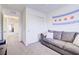 Bonus room with gray sofa, white walls and access to the rest of the house at 1132 Ruby Sparrow St, Henderson, NV 89011