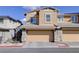 Home exterior featuring a tan two-car garage and stone veneer accents at 1132 Ruby Sparrow St, Henderson, NV 89011