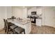 Kitchen boasts granite countertops, island with seating, and stainless steel appliances at 1132 Ruby Sparrow St, Henderson, NV 89011