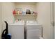 Practical laundry room features a washer, dryer, and storage shelf at 1132 Ruby Sparrow St, Henderson, NV 89011