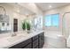 Bright bathroom with double vanity, soaking tub, and large window with neighborhood views at 11832 Dragontail Peak Ave, Las Vegas, NV 89138