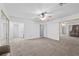 Spacious bedroom featuring plush carpeting, mirrored closets, and a ceiling fan at 1841 Golden Shadow Dr, Henderson, NV 89002