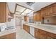 Traditional kitchen with wood cabinetry, tiled floors, and modern appliances at 1841 Golden Shadow Dr, Henderson, NV 89002