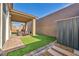 Rear patio and manicured lawn surrounded by brick borders and walls at 3491 Argiento Ave, Henderson, NV 89044