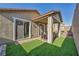 Outdoor patio with manicured lawn, covered seating area, and patio doors for indoor/outdoor living at 3491 Argiento Ave, Henderson, NV 89044