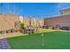 Beautiful backyard with manicured lawn, patio set and potted plants along the brick perimeter wall at 3491 Argiento Ave, Henderson, NV 89044