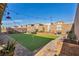 Spacious backyard with artificial grass, putting green, brick-paved area, and string lights for outdoor enjoyment at 3491 Argiento Ave, Henderson, NV 89044