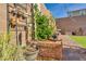 Close up of landscaped backyard with a decorative trellis, plants and a brick wall perimeter at 3491 Argiento Ave, Henderson, NV 89044