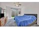 Comfortable bedroom with a gray carpet, ceiling fan, a sliding glass door, and decorative shelves at 3491 Argiento Ave, Henderson, NV 89044