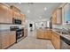 Modern kitchen boasts stainless steel appliances, granite countertops, and a breakfast bar, flowing into the open living space at 3491 Argiento Ave, Henderson, NV 89044