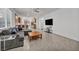 Cozy living room showcases a comfortable gray sofa, open layout, tile flooring, and seamless transition to the kitchen at 3491 Argiento Ave, Henderson, NV 89044