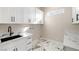 Bright laundry room with white cabinets, black hardware, and marble countertops at 3520 Malibou Ave, Pahrump, NV 89048